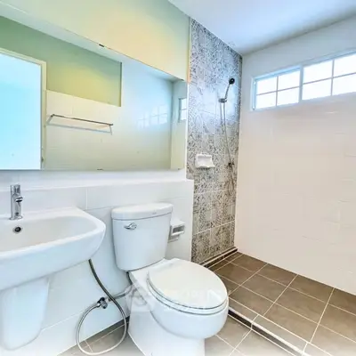 Modern bathroom with stylish tiles and sleek fixtures, featuring a shower and toilet.