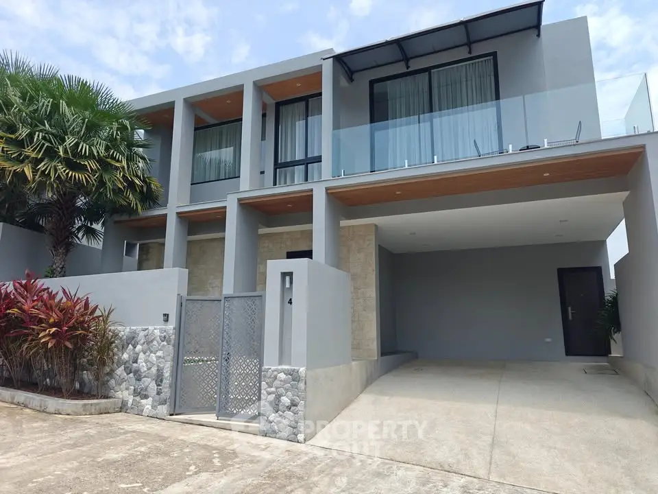 Modern two-story house with sleek design, large windows, and spacious driveway, surrounded by lush greenery.