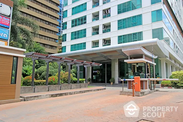 Modern building entrance with lush landscaping and security gate