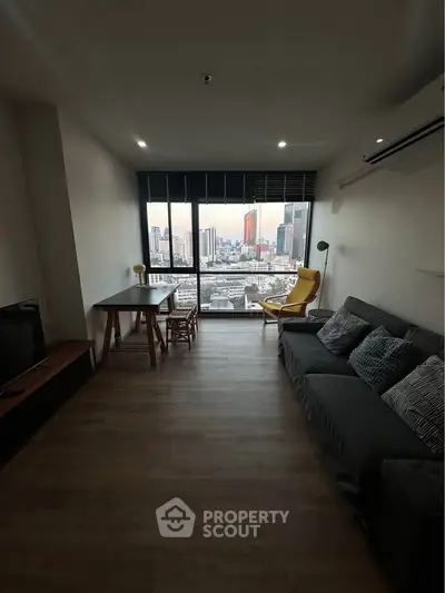 Modern living room with city view, stylish furniture, and large windows.