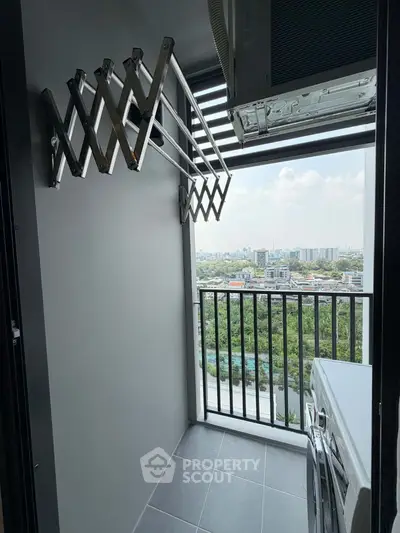 Modern balcony with laundry area and city view, featuring a washing machine and drying rack.