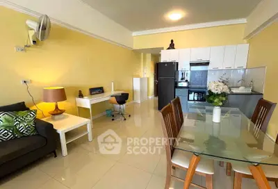 Modern open-plan living room with dining area and kitchen, featuring stylish furniture and bright decor.