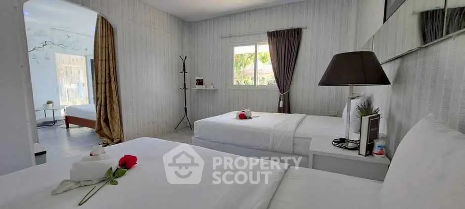 Spacious bedroom with twin beds and elegant decor, perfect for relaxation.
