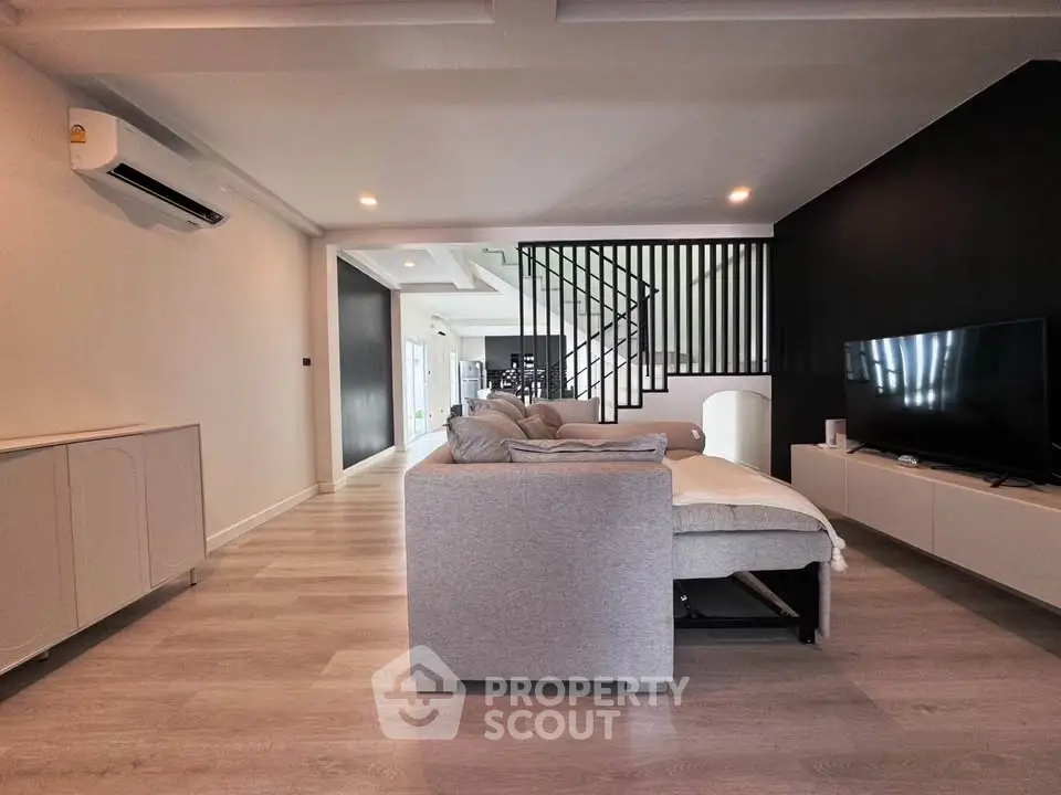 Spacious modern living room with sleek design and cozy seating area, perfect for relaxation and entertainment.