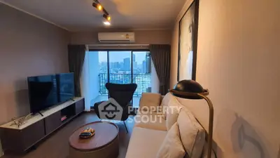 Modern living room with city view, featuring cozy sofa, stylish armchair, and large TV, perfect for urban living.