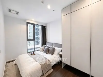 Modern bedroom with large window and stylish decor in urban apartment