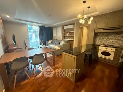 Modern open-plan living room and kitchen with stylish decor and hardwood floors.