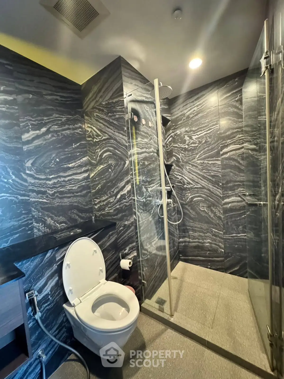Luxurious modern bathroom with elegant marble tiles and glass shower enclosure.