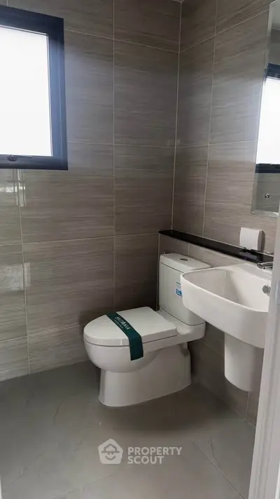 Modern bathroom with sleek tiles and contemporary fixtures in a stylish real estate property.
