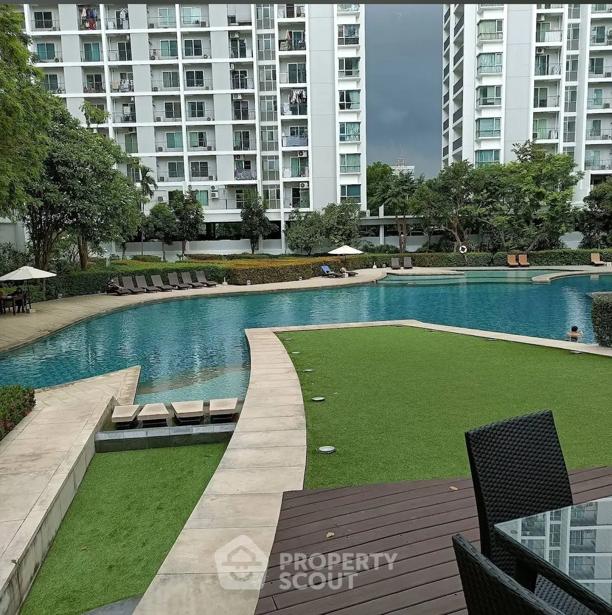 Luxurious apartment complex with stunning pool and lush greenery, perfect for relaxation and leisure.