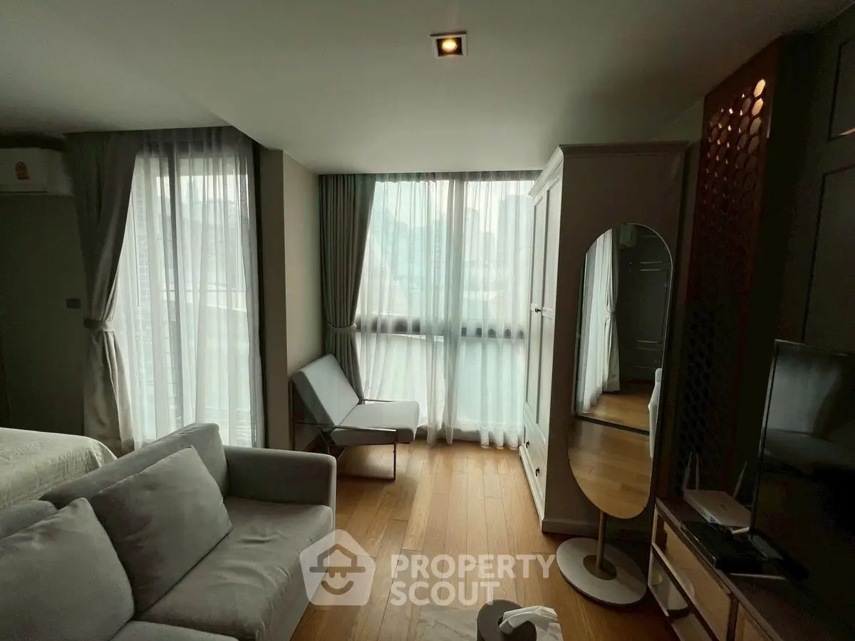 Modern living room with large windows and stylish furniture in a cozy apartment.