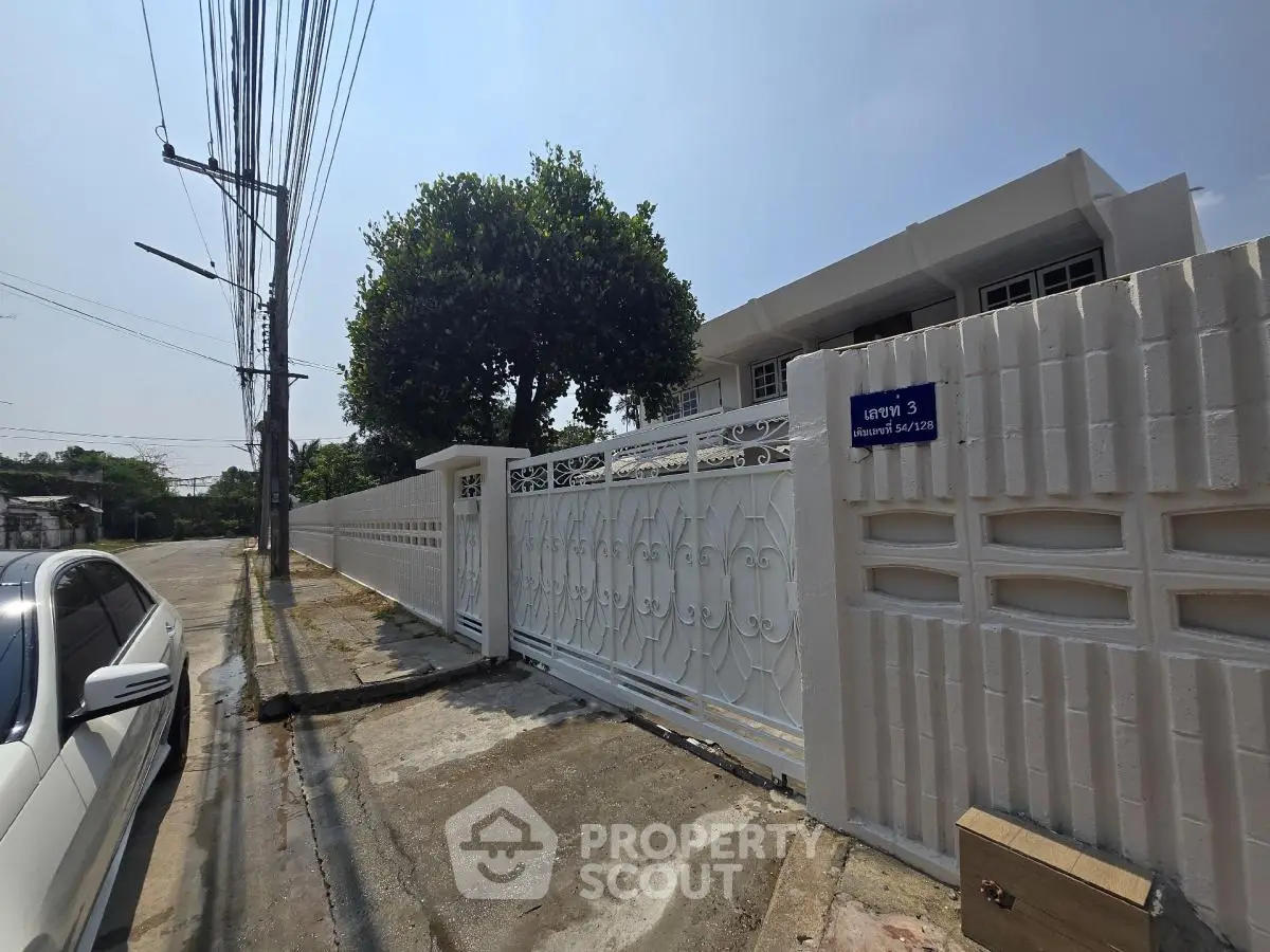 Charming suburban home with gated entrance and lush greenery, perfect for privacy and tranquility.