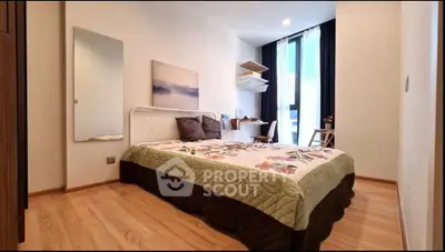 Modern bedroom with stylish decor and natural light, featuring a cozy bed and workspace.
