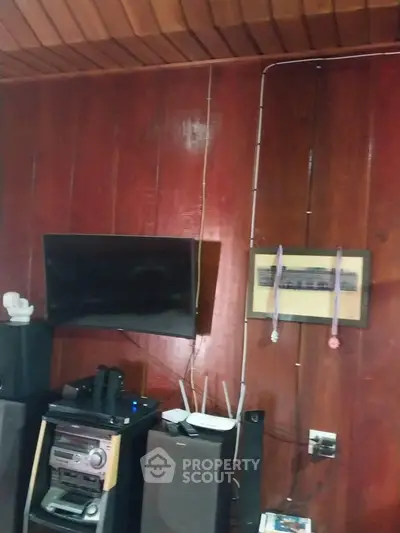 Cozy living room with wooden paneling and modern entertainment setup