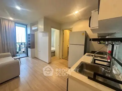 Modern open-layout kitchen and living area with balcony view in urban apartment