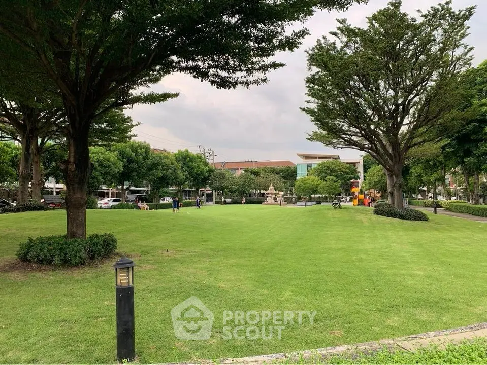 Spacious green garden with lush trees in a serene residential area.