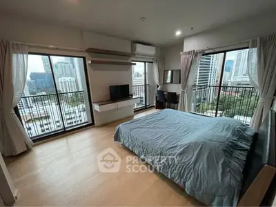 Spacious bedroom with city view and modern decor in high-rise apartment
