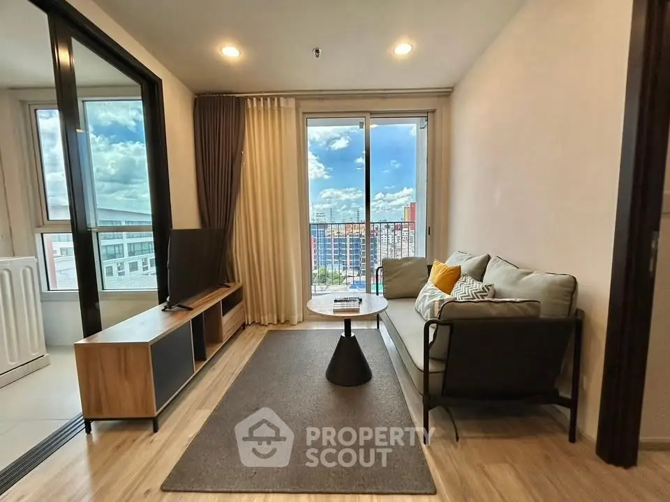 Modern living room with balcony view, stylish furniture, and natural light.