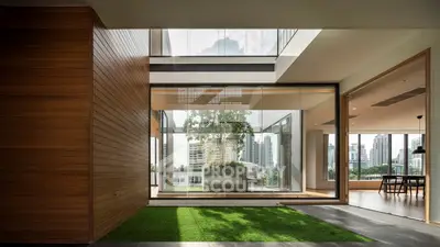 Luxurious modern home with open layout and stunning city views, featuring a lush indoor garden and sleek wooden accents.