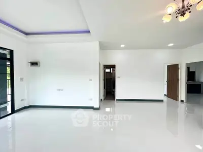 Spacious modern living room with sleek white tiles and elegant lighting, perfect for contemporary living.