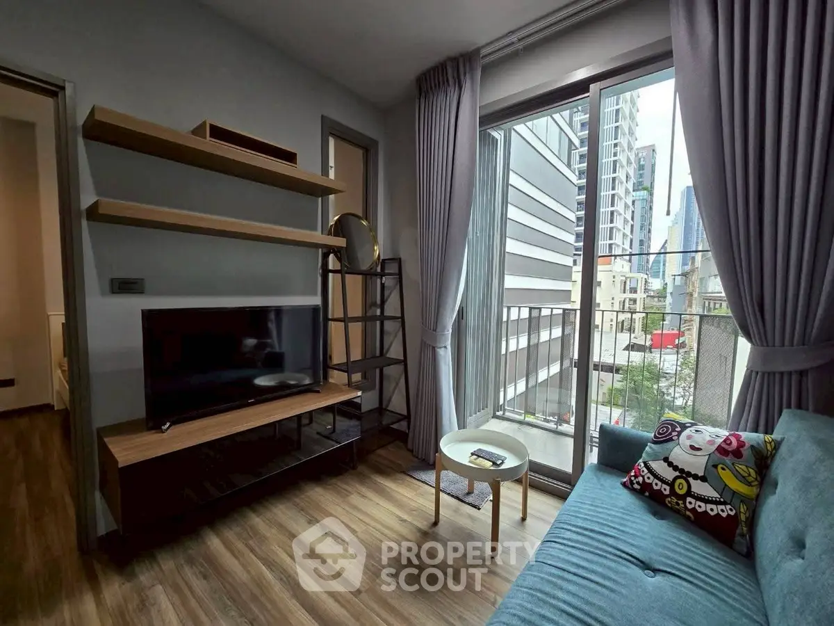 Modern living room with city view, featuring sleek furniture and large windows for natural light.