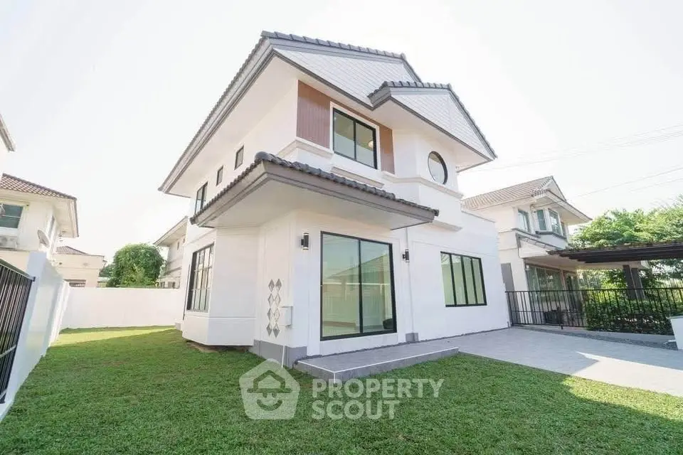 Modern two-story house with spacious lawn and large windows
