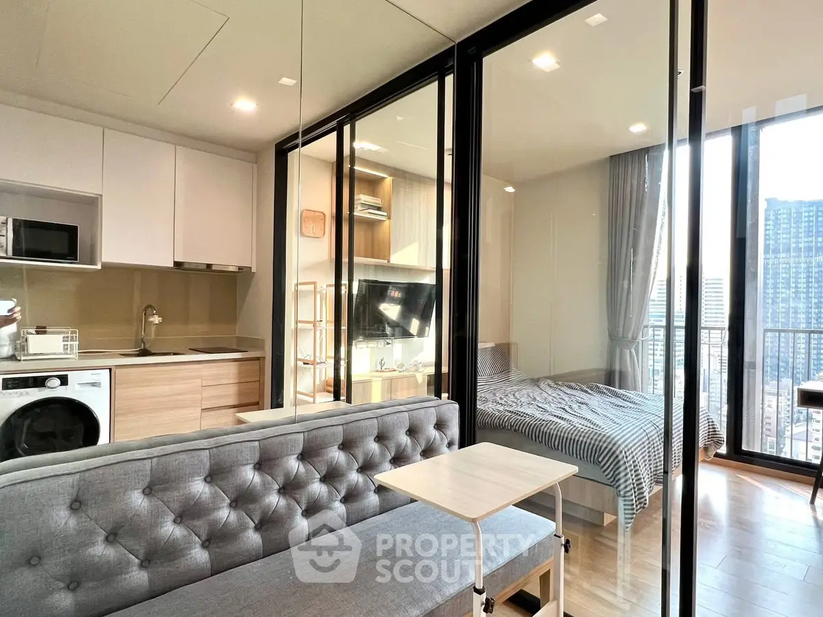 Modern apartment with open layout, featuring a cozy living area, sleek kitchen, and a bedroom with city views.