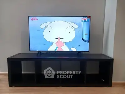 Modern living room with sleek TV stand and flat-screen TV displaying animation.