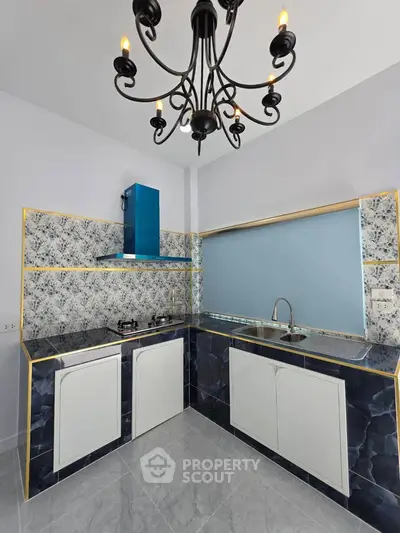 Modern kitchen with elegant chandelier and stylish blue backsplash