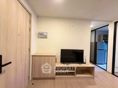 Modern living room with sleek wooden furniture and flat-screen TV, showcasing minimalist design.