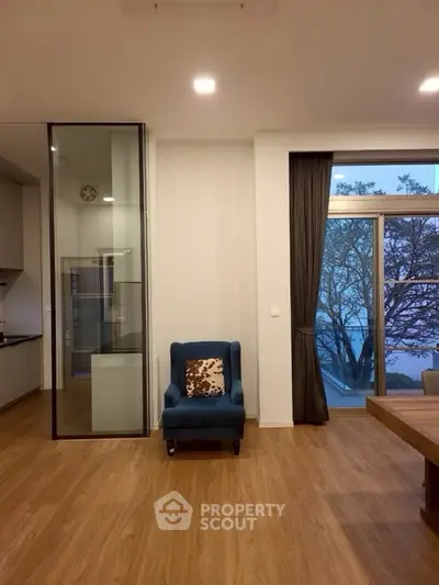Modern living room with elegant decor and large window offering scenic views.