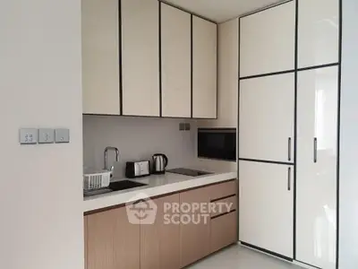 Modern kitchen with sleek cabinetry and built-in appliances in a contemporary apartment.