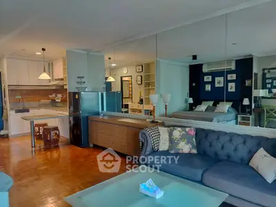 Spacious open-plan living room with modern kitchen and cozy bedroom area.