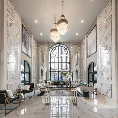 Luxurious living room with high ceilings, marble floors, and elegant chandeliers
