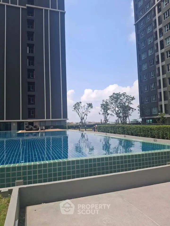 Modern apartment complex with a stunning outdoor pool and lush greenery.