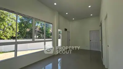 Spacious modern room with large windows and glossy tiled floor, perfect for natural light lovers.