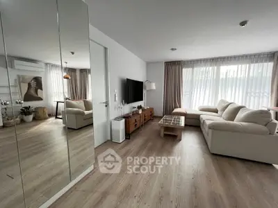 Spacious modern living room with cozy beige sofa and large windows