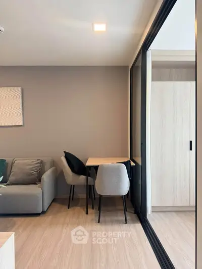 Modern living room with sleek furniture and large sliding glass doors leading to a balcony.