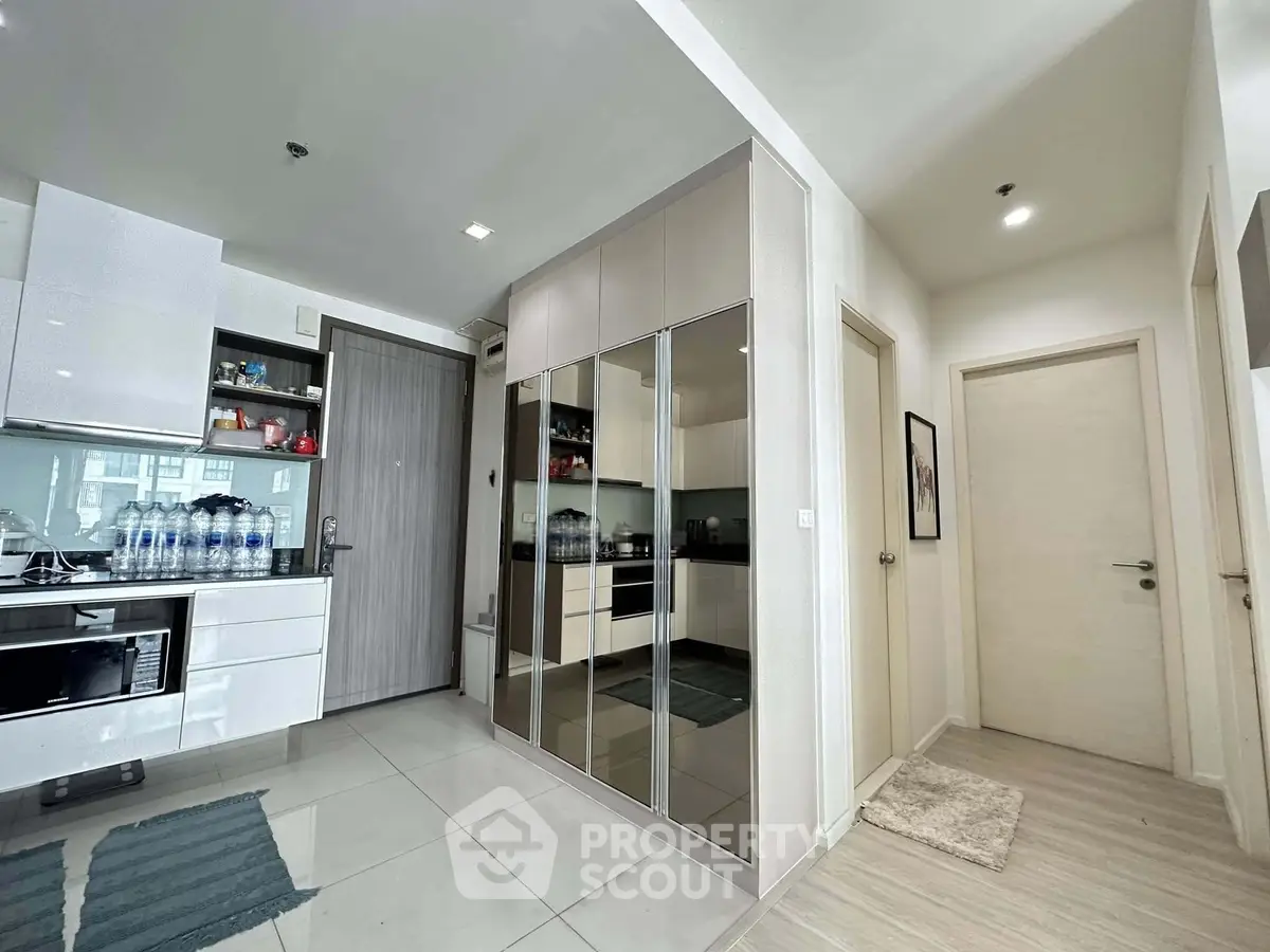 Modern apartment interior with sleek kitchen and mirrored storage cabinets