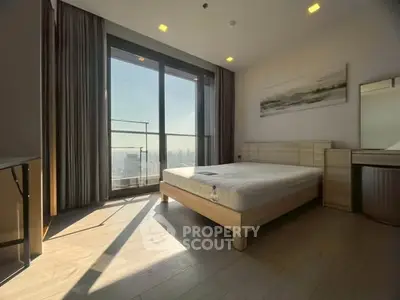 Spacious bedroom with large windows offering stunning city views and modern furnishings.