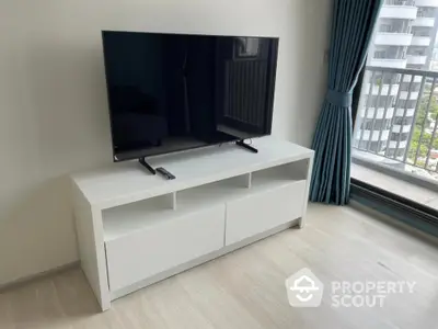 Modern living room with sleek TV stand and balcony view in urban apartment