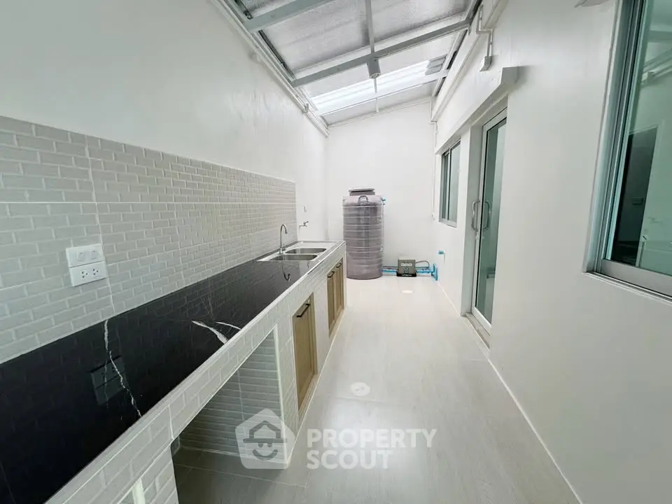 Modern kitchen with sleek black countertop and ample natural light