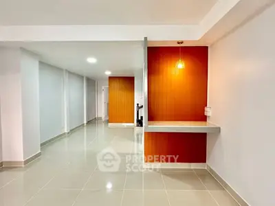 Spacious modern interior with sleek tiled flooring and vibrant accent wall.