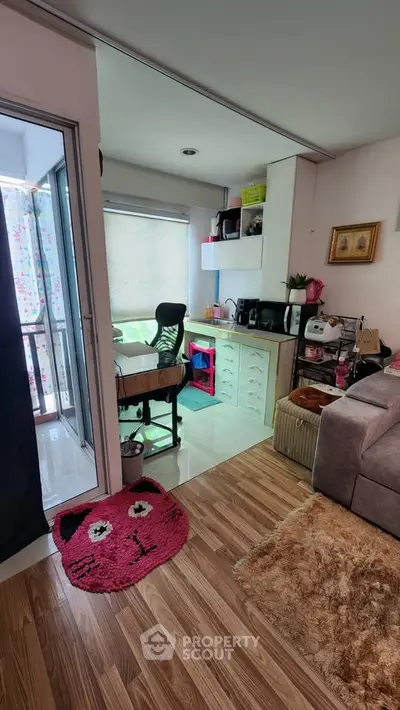 Cozy living room with home office setup and balcony access