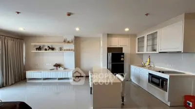 Modern open-layout kitchen with sleek white cabinetry and spacious living area