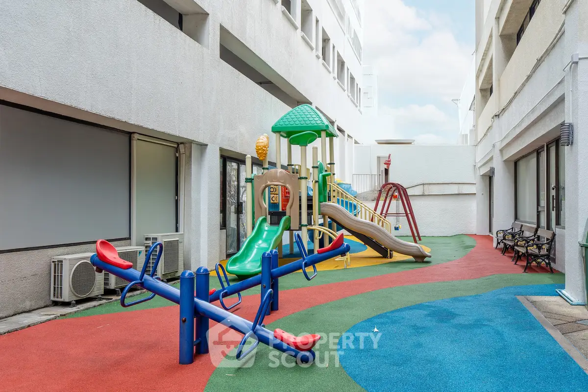 Modern apartment complex with vibrant playground area for families.