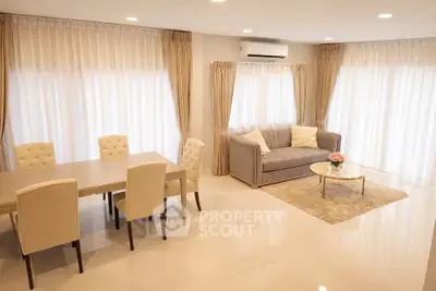 Spacious living room with elegant dining area and cozy seating, perfect for modern family living.