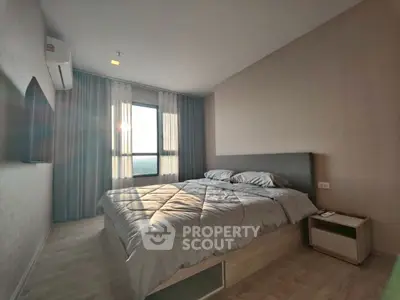 Modern bedroom with large window and stylish decor, featuring a comfortable bed and natural light.