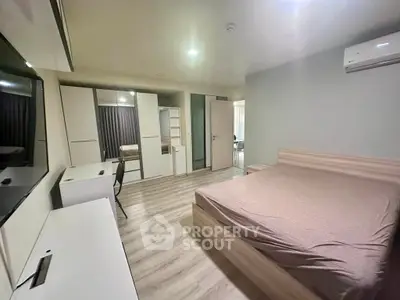 Spacious modern bedroom with sleek furniture and ample storage in a stylish apartment.