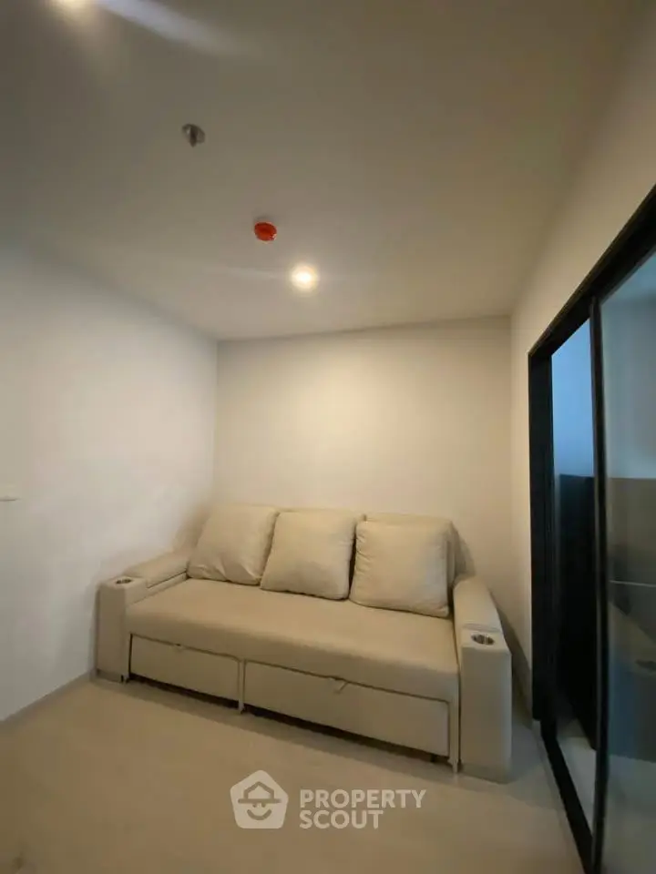 Cozy small living room with a comfortable sofa and modern sliding glass door.
